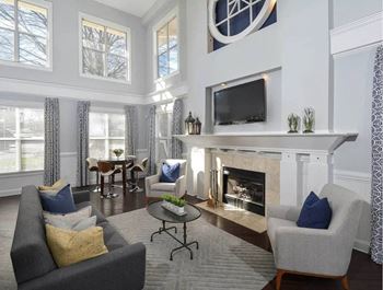 A living room with a grey couch, a fireplace, and a television.